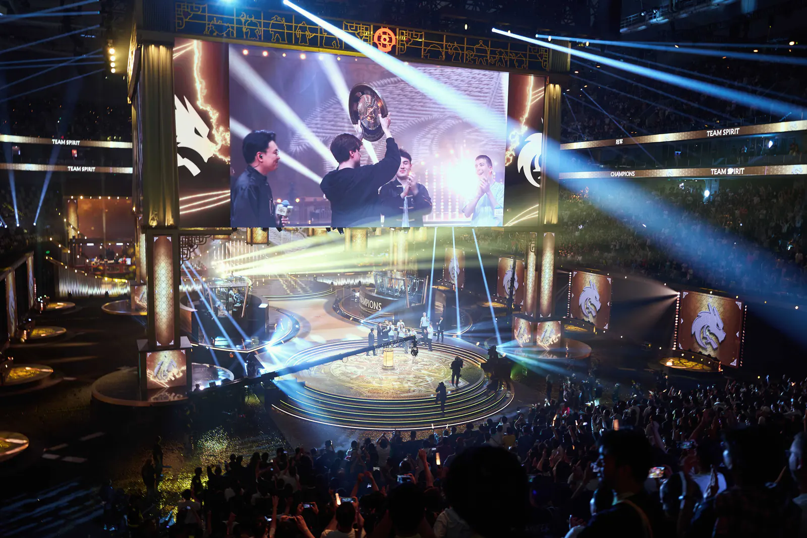 Победители финала DOTA 2 поднимают чемпионский трофей на сцене